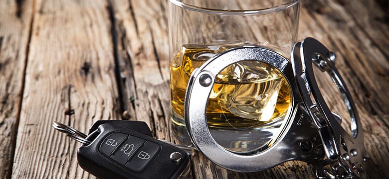 glass with keys and handcuffs on table highlighting dui penalties