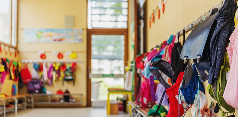 Daycare entrance with children's backpacks on hooks